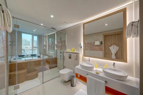 a bathroom with two sinks and a shower and a toilet at Al Khoory Atrium in Dubai
