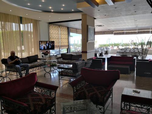 eine Lobby mit einer Person auf einem Stuhl in der Unterkunft Holiday Suites Hotel & Beach Resort in Jounieh