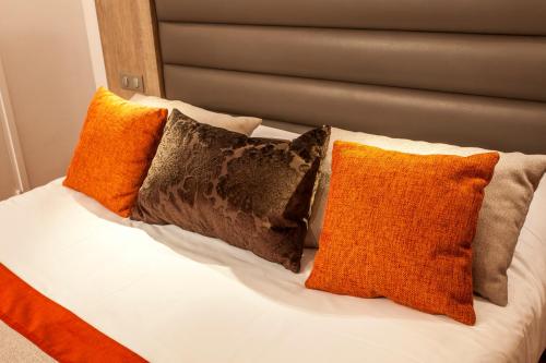 a bed with four pillows on top of it at Logis - Le Christina in Bourges