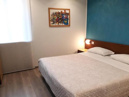 a bedroom with a bed and a painting on the wall at Hotel San Giorgio in Udine
