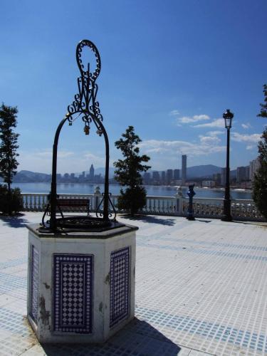 a bench in a park next to a body of water at Hotel Iris in Benidorm