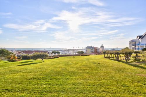 a park with green grass and trees and buildings at Appartement l'Archipel - Vue mer exceptionnelle et bassins aquatiques du 29 avril au 15 sept in Talmont