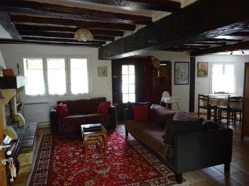 a living room with two couches and a table at Les chaumières du Chêne in Pouillé