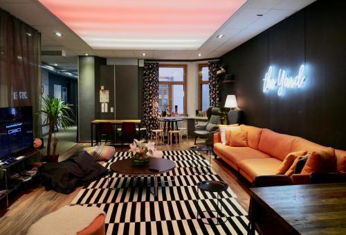 a living room with a couch and a tv at The Yard Hostel in Helsinki