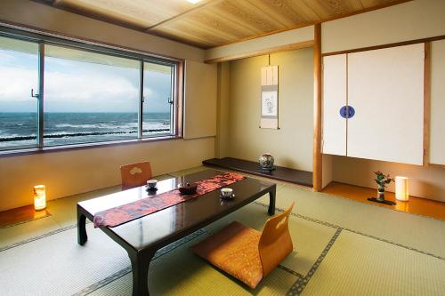 a living room with a table and a view of the ocean at Senami View Hotel in Senami