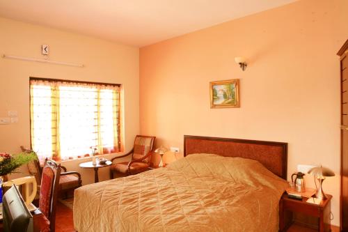 1 dormitorio con 1 cama, 1 silla y 1 ventana en Regant Lake Palace Hotel, en Nīndakara