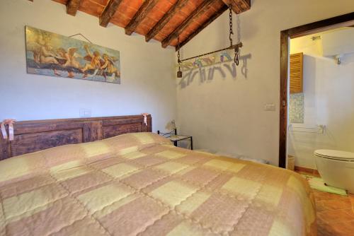 a bedroom with a bed and a bathroom with a tub at Casa Margherita 3 by PosarelliVillas in Piegaio