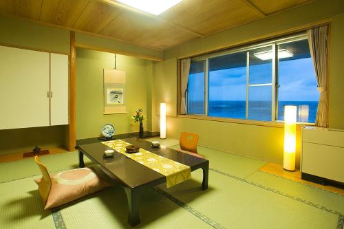 a living room with a table and chairs and a window at Senami View Hotel in Senami