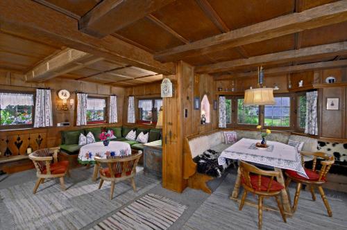 a living room with two tables and a couch at Ferienhäuser Reither Almen in Reith im Alpbachtal