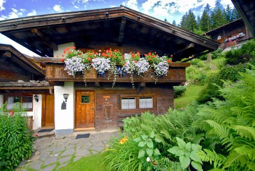a house with flowers on the side of it at Ferienhäuser Reither Almen in Reith im Alpbachtal
