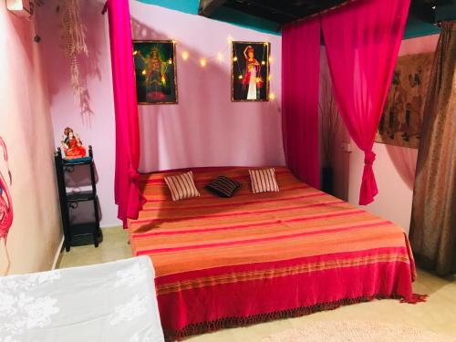 a pink bedroom with a bed with pink curtains at Cozy Dream Apartment in Anjuna