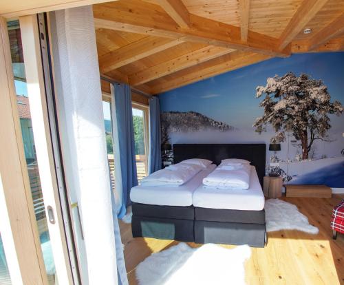 een slaapkamer met 2 bedden en een blauwe muur bij ALPENLIEBE Design Hotel in Inzell