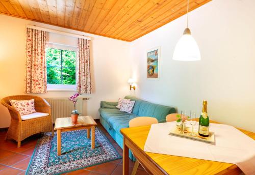 a living room with a blue couch and a table at Appartements im Park in Krumpendorf am Wörthersee