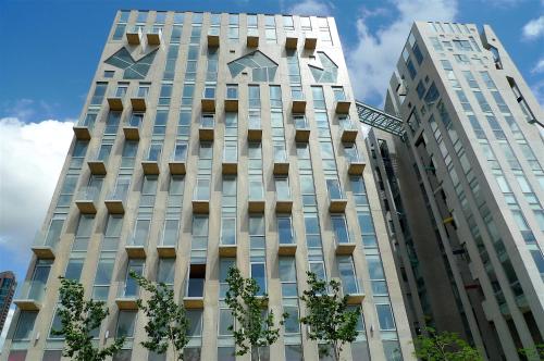 a tall white building with trees in front of it at Bossa Nova Beirut Hotel in Beirut