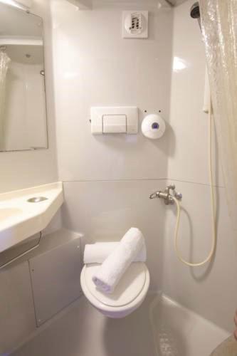 a white bathroom with a toilet and a sink at Première Classe Paris Ouest - Pont de Suresnes in Suresnes