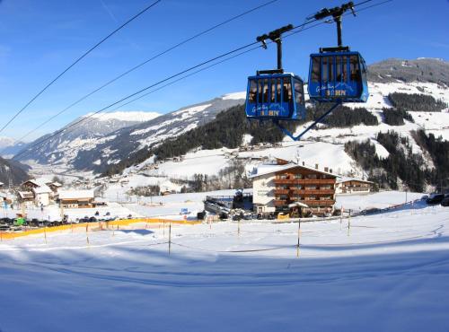 a ski lift flying over a snow covered mountain at Alpen Wohlfühlhotel Dörflwirt in Hainzenberg