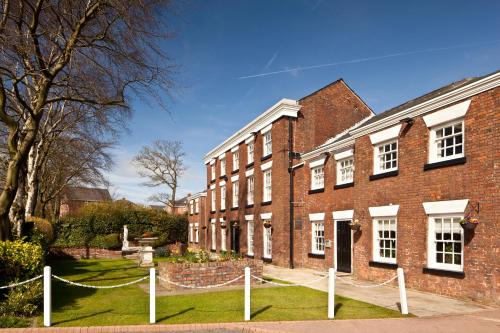 a brick building with a fence in front of it at Mercure Bolton Georgian House Hotel in Bolton