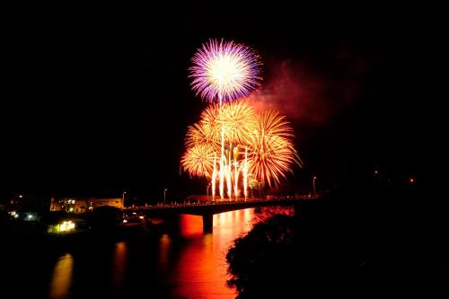 a firework display in the sky over a bridge at Hotel Yakushima Sanso in Yakushima