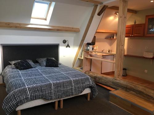 a bedroom with a bed with a checkered blanket at Les chaumières du Chêne in Pouillé