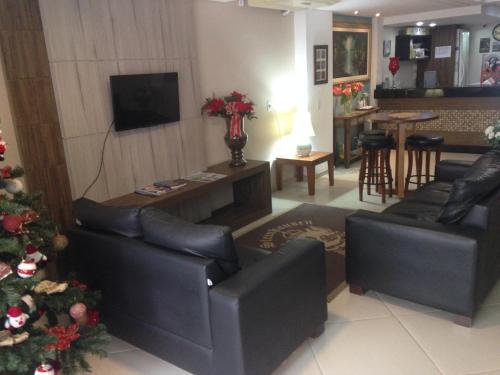 a living room with two couches and a christmas tree at Hotel Steinhausen in Blumenau