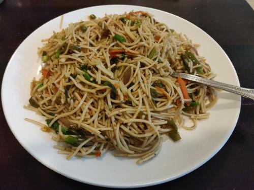 ein Teller mit Essen und Nudeln auf einem Tisch in der Unterkunft Heritage Nirvana Villa - 4BHK, Goa in Calangute