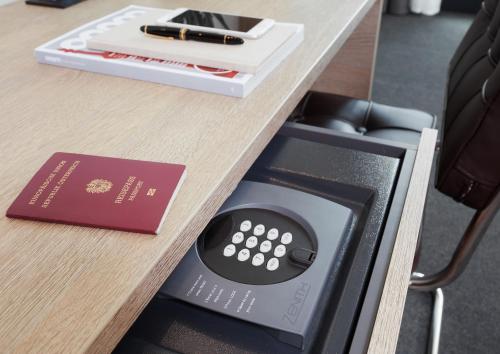 a desk with a passport and a remote control at Living Hotel Frankfurt in Frankfurt/Main