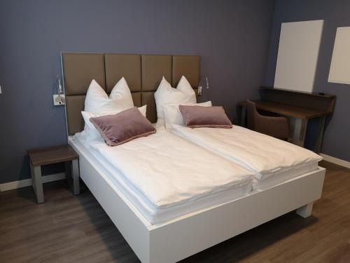 a large white bed with two pillows on it at Trip Inn PostApart Aschaffenburg in Aschaffenburg