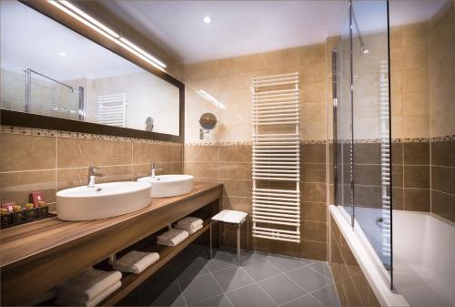 een badkamer met 2 wastafels en een douche bij Remisens CASA ROSA - Hotel Metropol Annexe in Portorož