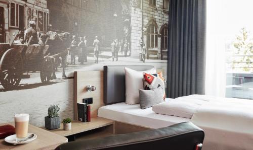 a bedroom with a white bed and a black and white photo at Living Hotel Frankfurt in Frankfurt/Main