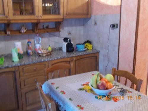 a kitchen with a table with a bowl of fruit on it at Appartamento I Cedri in San Cesareo