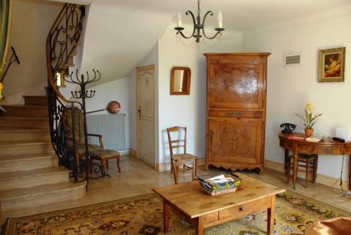 ein Wohnzimmer mit einer Treppe und einem Tisch in der Unterkunft Le Logis du Port in Domme