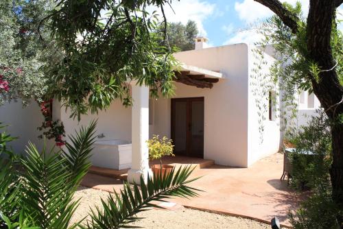 a white house with a courtyard and trees at Agroturismo Can Pere Sord in Sant Joan de Labritja