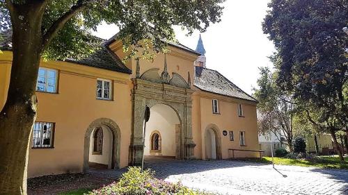 a large yellow building with an archway in a yard at Apartments Am Spitalthor in Straubing