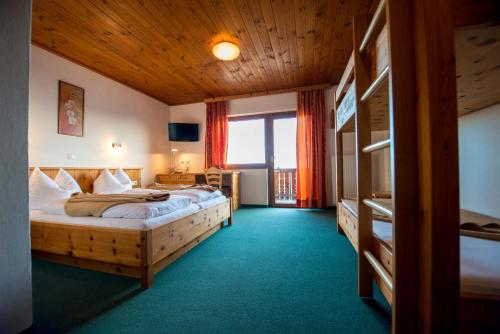 a hotel room with two beds and a balcony at Almhotel Fichtenheim in Berg im Drautal