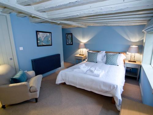 a bedroom with a large white bed and a chair at Anchor Inn in Hartfield