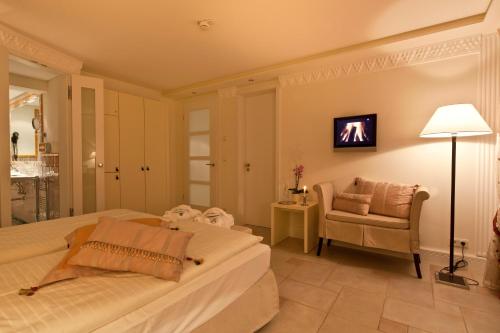 a bedroom with a bed and a chair and a lamp at Boutiquehotel La Casa in Tübingen