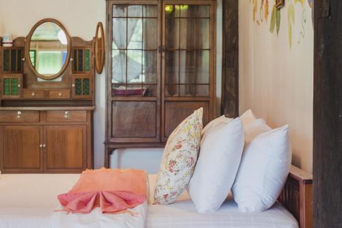 a room with a bed with pillows and a mirror at Baan Imm Sook Resort in Chao Lao Beach