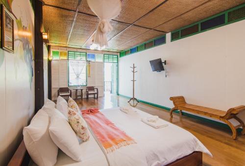 a room with a bed and a bench in it at Baan Imm Sook Resort in Chao Lao Beach