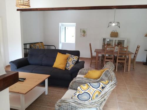 a living room with a couch and a table at Montejunto Villas - Casa do Plátano in Cadaval