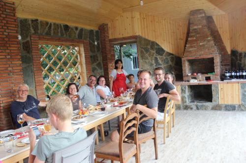 a group of people sitting at a table eating at Guesthouse Alvani in Nizhniy Alvani