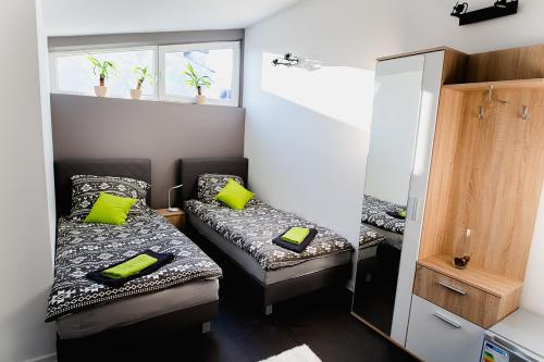 ミエレツにあるNOCLEGI HOSTEL CENTRUM MIELECの小さな部屋で、ベッド2台、鏡が備わります。