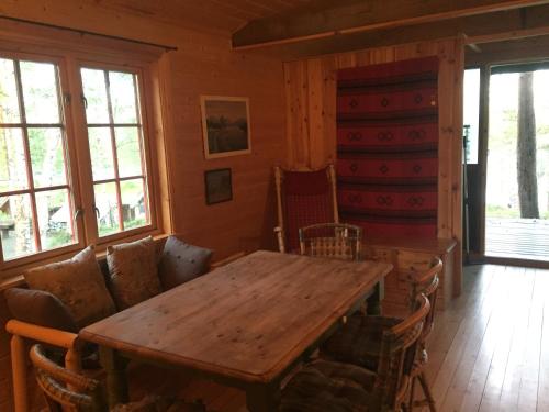 comedor con mesa de madera y sillas en Birk Husky - guesthouse & cabins, en Svanvik