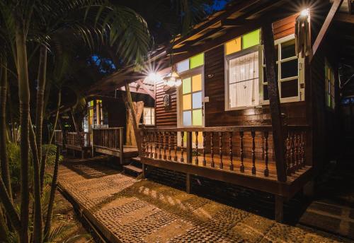 a wooden house with lights on it at night at Baan Imm Sook Resort in Chao Lao Beach