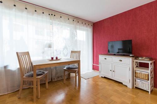 a dining room with a table and a tv at Ferienwohnung M. Broghammer in Oberstdorf