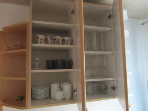 a cupboard full of cups and dishes in a room at Ferienwohnungen Fuchshuber in Neukirchen vorm Wald