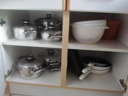 a cabinet with pots and pans and other kitchen utensils at Ferienwohnungen Fuchshuber in Neukirchen vorm Wald