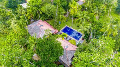 an overhead view of a house with a swimming pool at Araliya Gardens Hotel in Hikkaduwa
