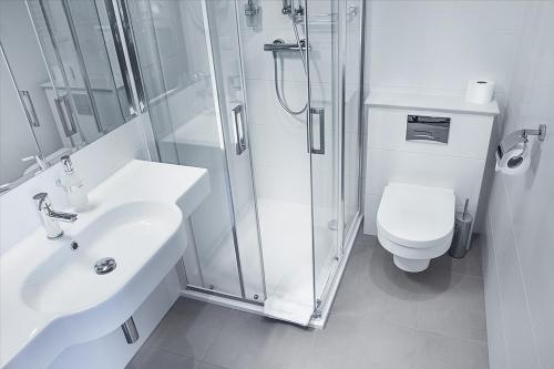 a bathroom with a shower and a sink and a toilet at GRAND HOTEL Kielce in Kielce