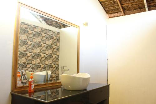 a bathroom with a large mirror and a sink at Sea Shades Palolem Resort in Palolem