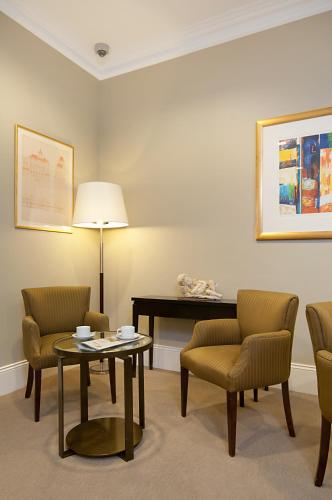 a waiting room with chairs and a table and a desk at Adabco Boutique Hotel Adelaide in Adelaide